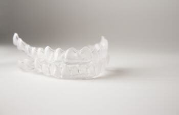 Clear dental aligners placed on a white surface.